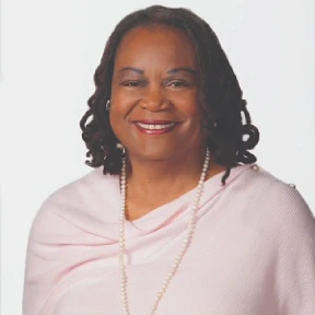 Portrait of a woman with short curly hair and a pink shawl.