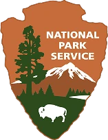 National Park Service emblem with a tree, mountain, and bison.